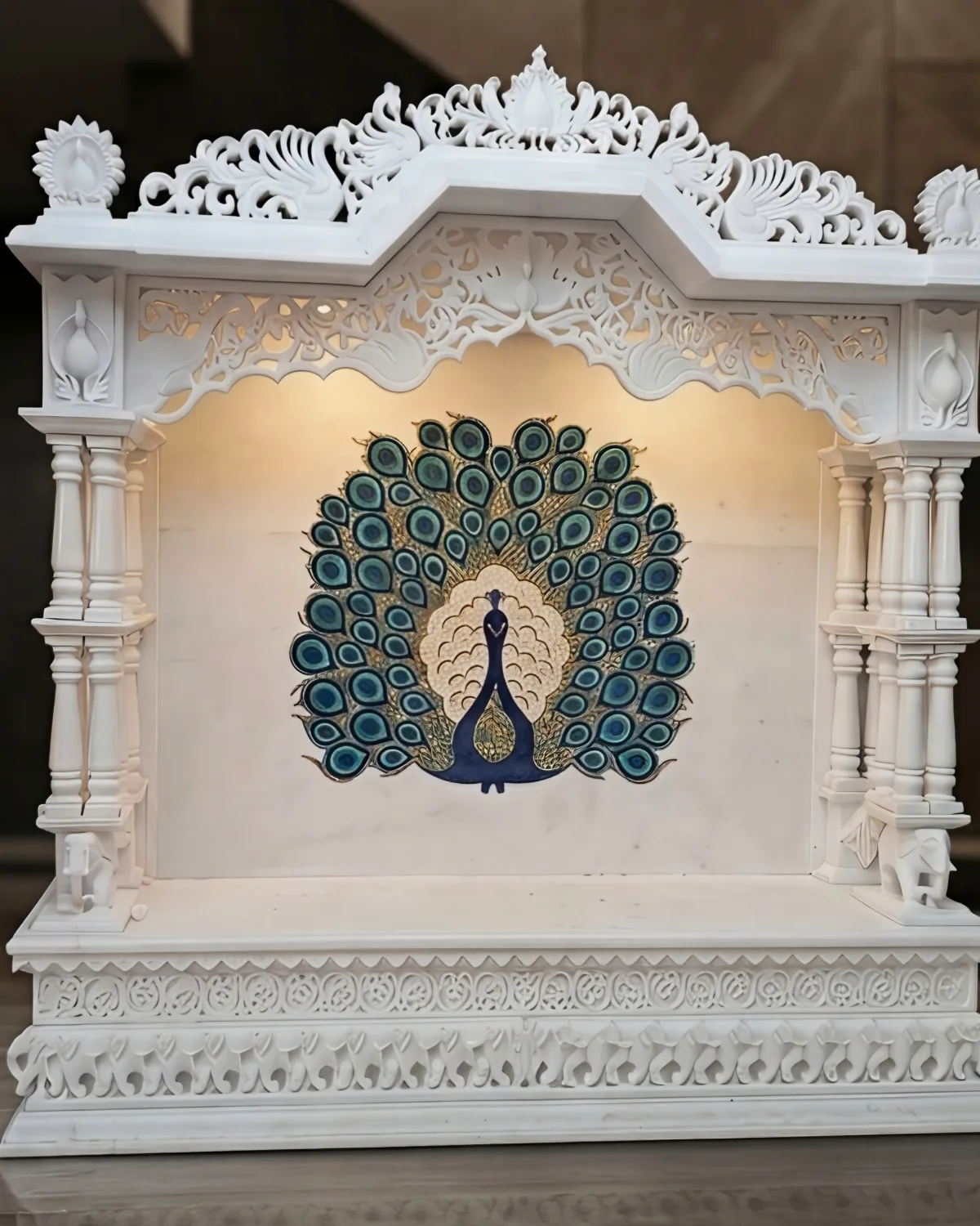 Makrana marble mandir with a carved jali arch and a large peacock stone inlay panel